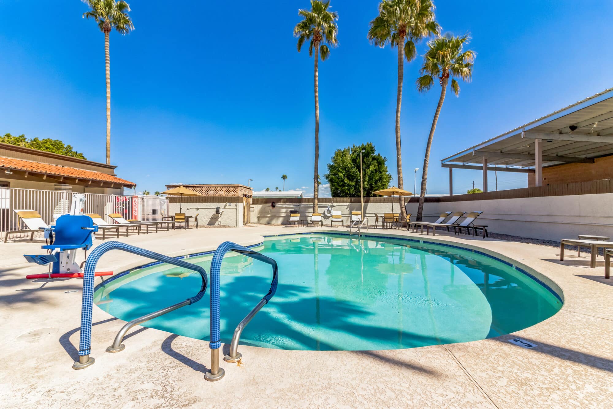 Manufactured home swimming pool with lounge chairs in Mesa, Arizona.